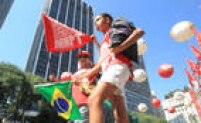 Manifestantes munidos de bandeiras e balões nas cores do Partido dos Trabalhadores começam a ocupar o centro de São Paulo