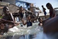 Crianças brincam no Rio em uma piscina sem sistema de drenagem e limpeza de água