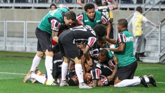Carlos é esmagado por companheiros após marcar o gol de empate no clássico com Cruzeiro