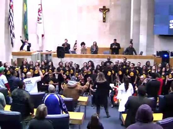 TV Câmara/Reprodução Culto. Louvorzão SP, evento com coral da Igreja Universal do Reino de Deus; à esquerda, na tribuna, Jean Madeira (PRB)