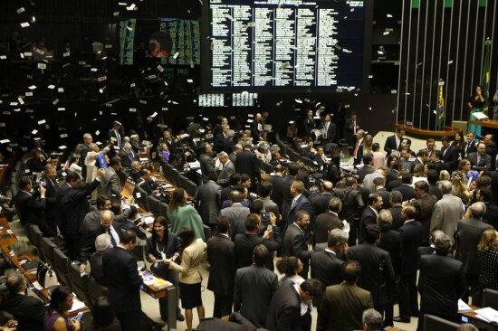 Manifestantes jogam dinheiro falso sobre as bancadas ocupadas por parlamentares do PT, na Câmara