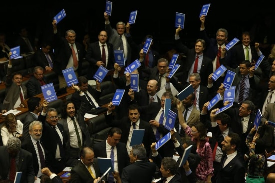 Parlamentares contrários à terceirizacão mostram carteiras de trabalho durante a votacão da emenda no Plenário da Câmara