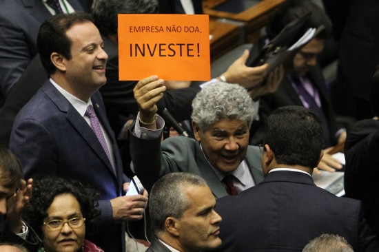 Deputado Chico Alencar (PSOL-RJ) levanta cartaz contra proposta de financiamento