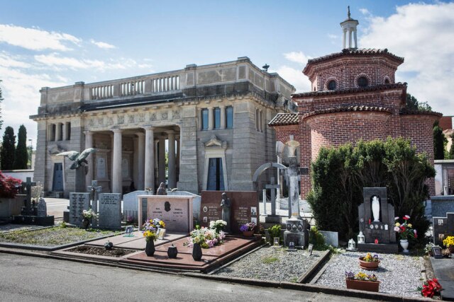CreditGianni Cipriano para The New York Times O túmulo da família, em primeiro plano, no centro, com flores e uma estátua.