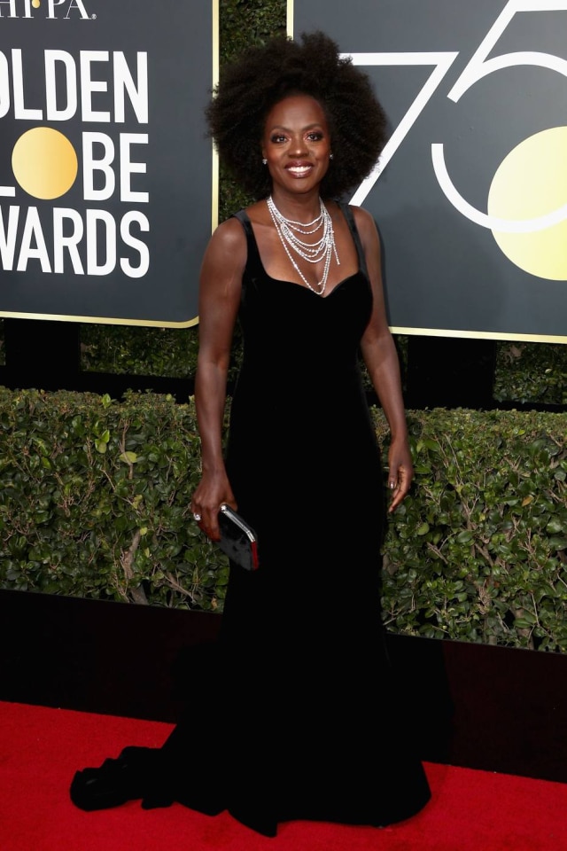 Frederick M. Brown/Getty Images/AFP Viola Davis surgiu no tapete vermelho do Globo de Ouro com o seu cabelo natural. O vestido de veludo, com modelagem reta, ganhou como complemento um grande colar de brilhantes