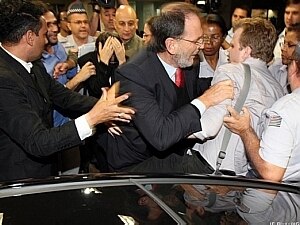 Momento em que repórter é empurrado. Ao fundo, Ana de Hollanda protege a cabeça com as mãos - JF Diorio/AE Momento em que repórter é empurrado. Ao fundo, Ana de Hollanda protege a cabeça com as mãos - JF Diorio/AE