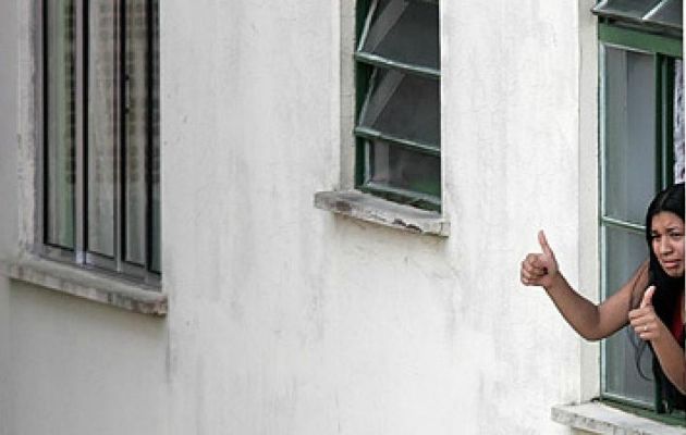 Ainda viva, Elo&aacute; acena da janela do apartamento onde era mantida ref&eacute;m pelo ex-namorado