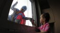 'Super-heróis' limpam janelas de hospital e animam crianças