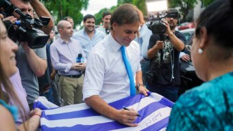 Luis Lacalle Pou autografa bandeira do Uruguai; nas fileiras do Partido Nacional, a garantia é que a agenda e as promessas serão cumpridas Foto: AP Photo/Matilde Campodonico
