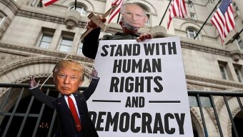 Ativista vestido de Putin manipula um boneco de Trump num protesto realizado em frente ao hotel do ex-presidente em Washington, para criticar o autoritarismo de ambos. Foto: Carlos Barria/Reuters