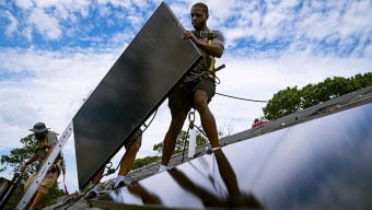 Trabalhadores instalam painéis solares em edifício comercial e residencial em Nova York, no dia 11 de agosto. Nova lei oferece incentivos para impulsionar energia limpa Foto: John Minchillo / AP