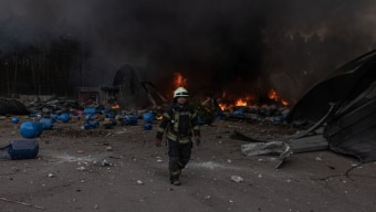 Bombeiro tenta apagar incêndio em armazém causado por ataque russo em cidade de Kiev, na Ucrânia. Foto: Roman Pilipey/EFE