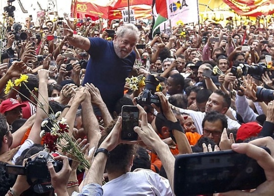 Lula é carregado após discurso em que disse que se entregará. Foto: Miguel Schincariol/AFP