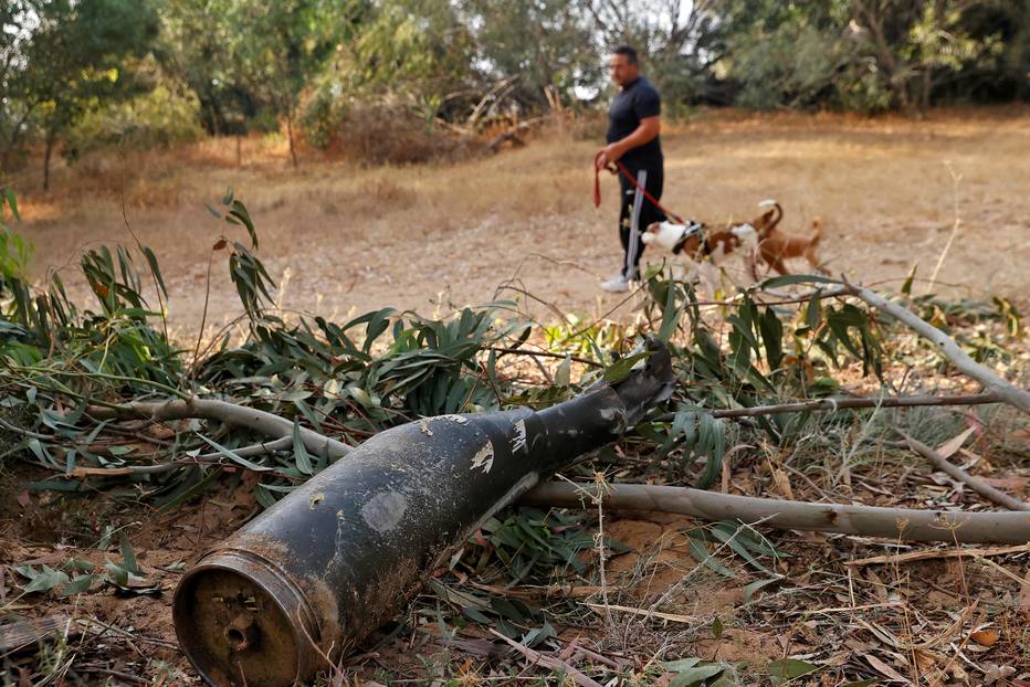 Israelense passa por destroço de foguete lançado pelo Hamas e interceptado pelo Domo de Ferro