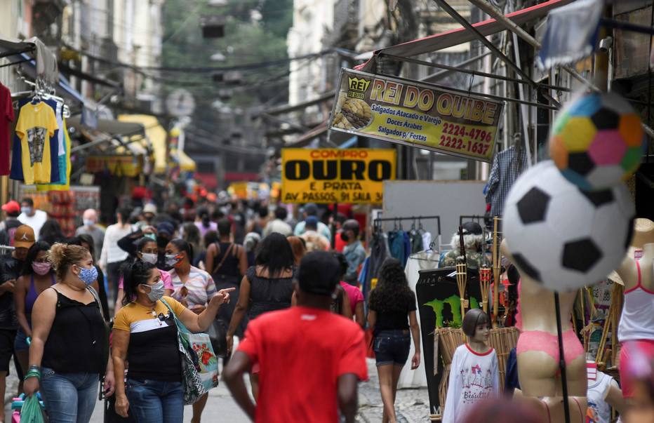 Pessoas andam em uma rua comercial popular no Rio de Janeiro.