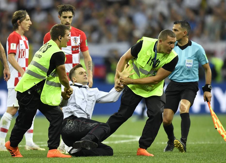Piotr Verzilov é retirado do estádio Luzhniki, em Moscou, após invadir a partida final da Copa de 2018 com 3 ativista do Pussy Riot