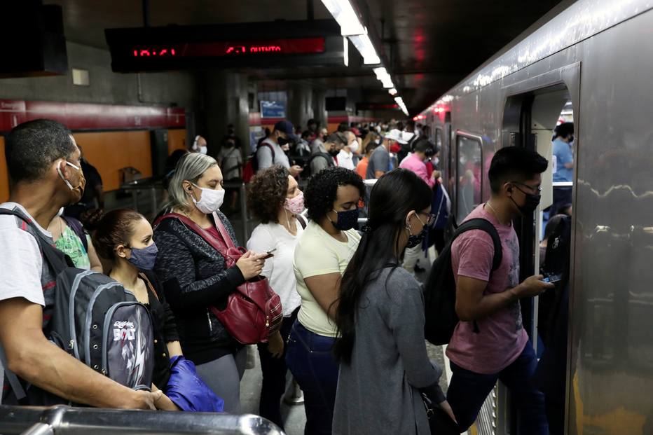 Passageiros com máscaras protetoras se reúnem para entrar no trem em uma estação de metrô em meio ao surto por coronavírus, em São Paulo.