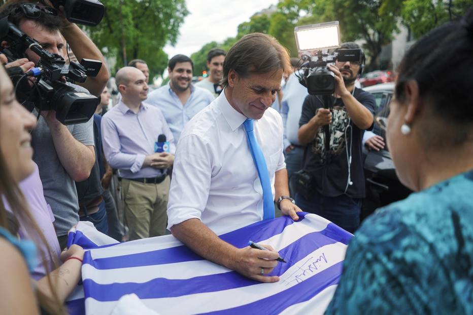 Luis Lacalle Pou autografa bandeira do Uruguai; nas fileiras do Partido Nacional, a garantia é que a agenda e as promessas serão cumpridas