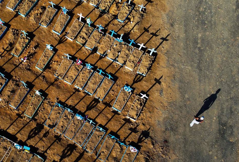 Esta foto de arquivo tirada em 21 de junho de 2020 mostra uma vista a&eacute;rea mostrando um homem passando por t&uacute;mulos no cemit&eacute;rio de Nossa Senhora Aparecida, em Manaus. 