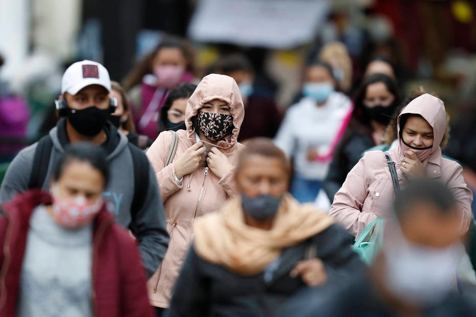 Pedestres de máscara caminham na região do Brás, em São Paulo