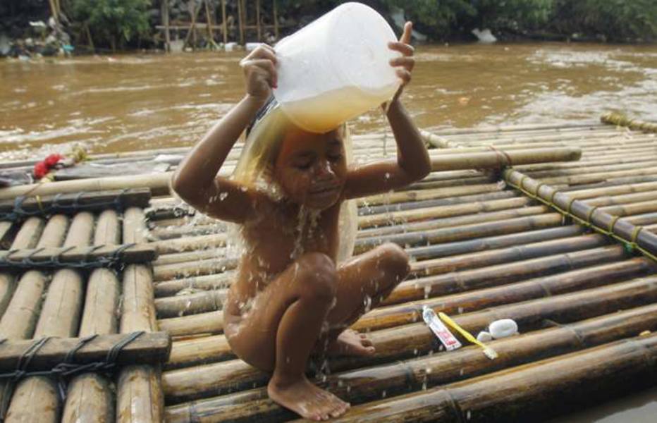 Menina se banha em rio poluído, Jakarta, na Indonésia; cidade tem mais de 9 milhões de habitantes