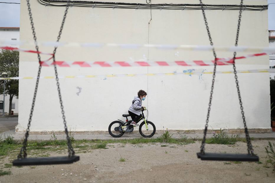 Criança anda de bicicleta perto de casa na Espanha