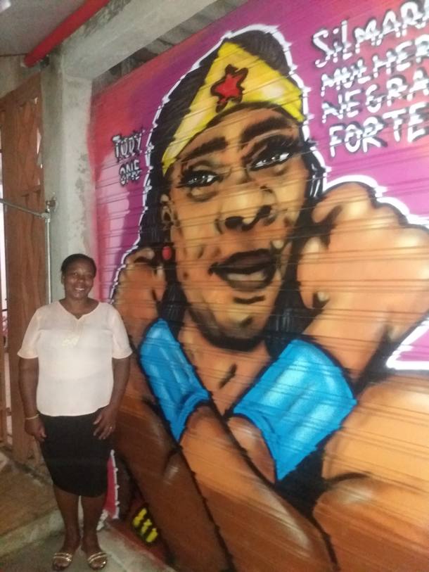 Silmara Moraes em frente ao grafite feito em sua homenagem, assinado pelo artista Tody