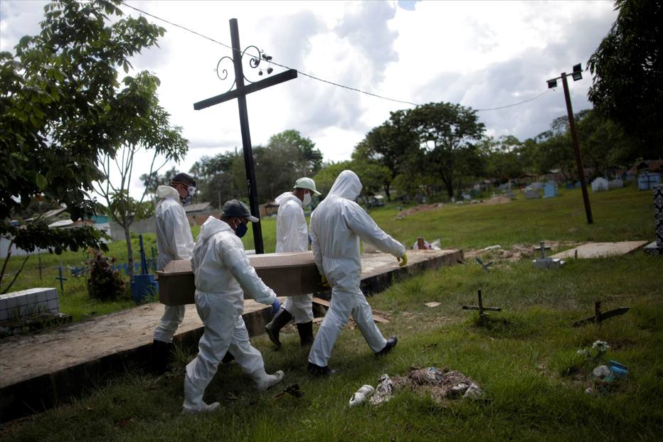 Coveiros vestindo roupas de proteção se preparam para enterrar o caixão de Manuel Farias, 70 anos, que morreu por coronavírus (COVID-19), no cemitério Recanto da Paz, em Breves, a sudoeste da ilha de Marajó, no estado do Pará. 