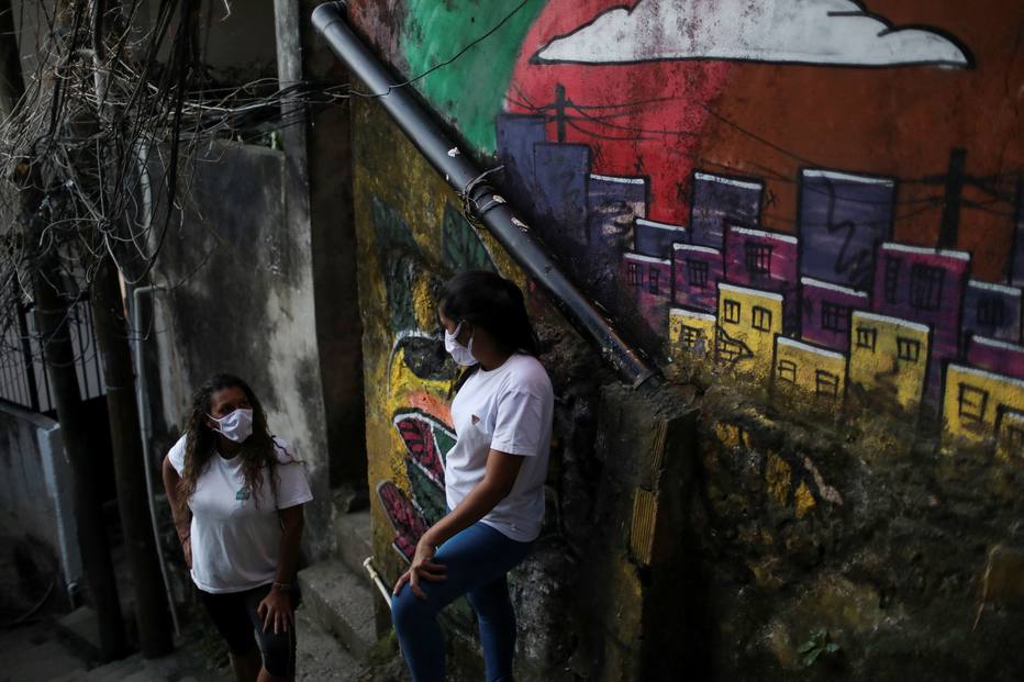 Técnicas de enfermagem descansam durante a assistência voluntária às famílias mais vulneráveis, no Rio de Janeiro.