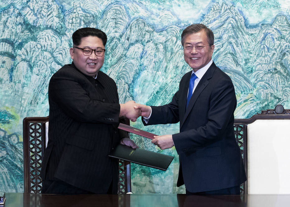 Kim Jong-un (E) e Moon Jae-in trocam cópias da Declaração de Panmunjom, em 27 de abril