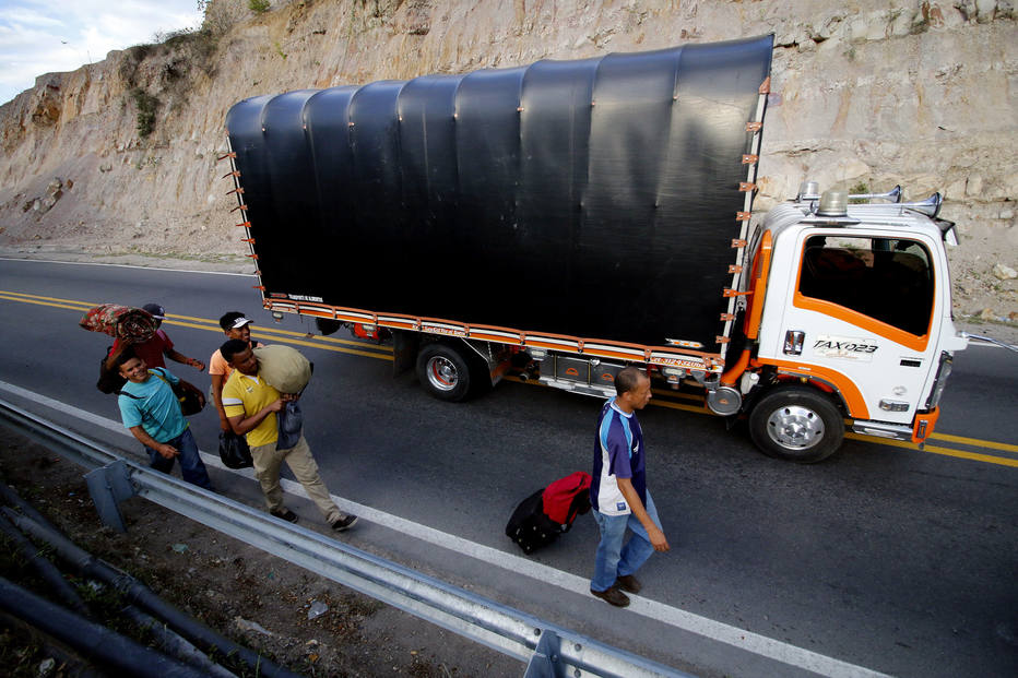 Venezuelanos caminham à margem de estrada colombiana perto de Cúcuta, na fronteira dos dois países