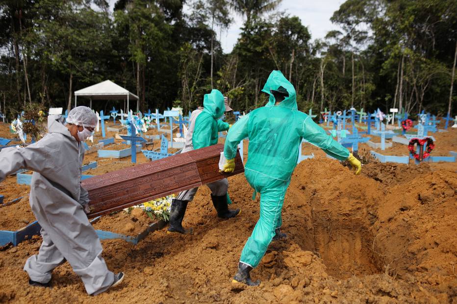 Coveiros trabalham durante o enterro de uma pessoa falecida devido &agrave; doen&ccedil;a de coronav&iacute;rus (COVID-19), no cemit&eacute;rio Parque Taruma, em Manaus.