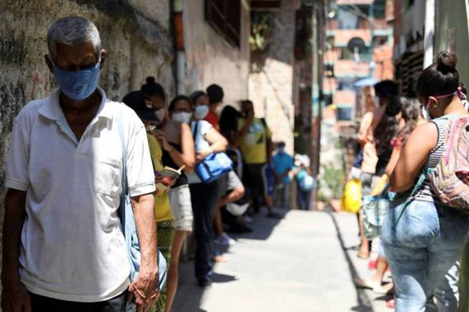Pessoas fazem fila para receber alimentos em meio a pandemia do novo coronav&iacute;rus. 