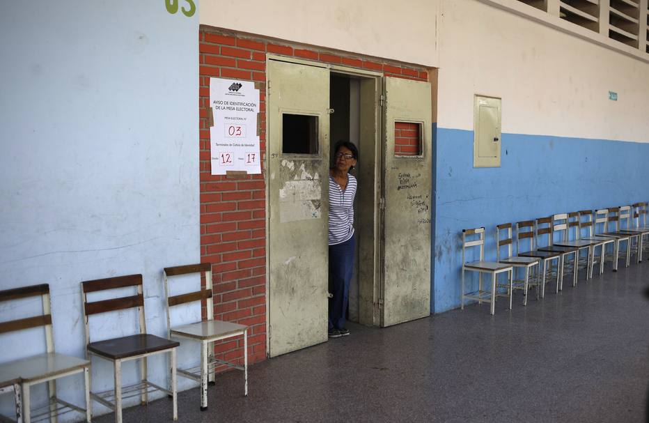 Mesária aguarda a chegada de eleitores em posto de votação que passou a maior parte do dia vazio em Caracas