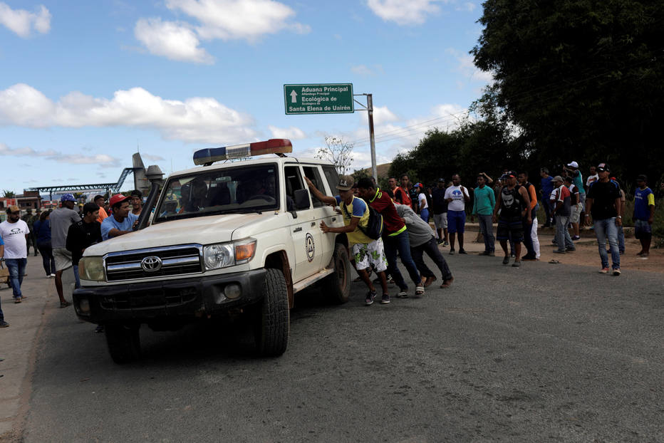 Venezuelanos socorrem feridos por ação da Guarda Nacional Bolivariana para ambulância que transportou as vítimas até hospitais no Brasil