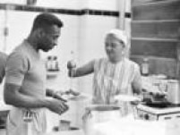 Dona Maria Toledo, cozinheira da Vila Belmiro, serve Pelé no refeitório do Santos, década de 1960.