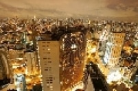 Vista do Edifício Copan iluminado durante o anoitecer da cidade de São Paulo.