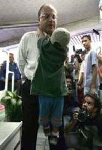 O candidato à Prefeitura pelo PP, Paulo Maluf (c), brinca com garotinho durante campanha pelo bairro do Itaim Paulista, 7/8/2004.