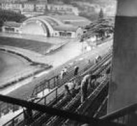 Operários reparam as arquibancadas do Estádio Municipal Paulo Machado de Carvalho, em 04/01/1962. A concha acústica, ao fundo, tem seu arco decorado com uma saldação à Seleção, campeã da Copa do Mundo de 1958