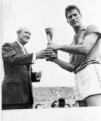 O capitão da Seleção, Bellini, recebe a taça Jules Rimet após a conquista da Copa do Mundo de 1958.