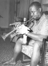 O cantor e trompetista americano Louis Armstrong limpa seu trompete no quarto onde estava hospedado no Hotel Jaraguá, em São Paulo, 23/11/1957.