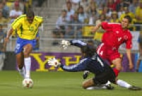 Rivaldo disputa bola com o goleiro da seleção da Turquia enquanto o zagueiro turco, Fatih Akyel, observa a jogada, na partida de estreia do Brasil na Copa do Mundo do Japão, 03/6/2002. O Brasil venceu a partida de estreia por 2 a 0. 