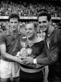  O técnico Vicente Feola segura a taça Jules Rimet ao lado do capitão Hideraldo Luiz Bellini e do goleiro Gilmar dos Santos Neves após o Brasil vencer a Suécia e conquistar seu primeiro título no mundial, 29/6/1958. 