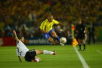 O jogador Roberto Carlos salta sobre atleta da Alemanha, na final da Copa do Mundo, no Yokohama International Stadium, em Yokohama, no Japão, 30/6/2002. 