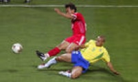 Roberto Carlos, lateral esquerdo da Seleçãoo Brasileira, divide bola com Yunlong Xu, da China, durante partida da segunda rodada da primeira fase da Copa do Mundo, 08/6/2002.