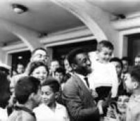 Pelé segura menino no colo, ao ser recepcionado por torcedores no Aeroporto de Congonhas, depois de uma partida pela Seleção Brasileira.São Paulo, SP,  08/7/1965.