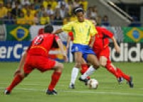 O atacante da Seleção Brasileira, Ronaldinho (11), tenta passar pelo marcador Jacky Peeters (15), na partida contra a Bélgica. A partida terminou com a vitória brasileira de 2 a 0 sobre a seleção belga. 