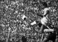 Com o corpo no ar, Pelé prepara-se para dominar a bola, disputando o lance com um zagueiro do Paraguai. O Brasil venceu por 3 a 0. Eliminatórias da Copa de 70, em Assunção, Paraguai, 04/8/1969.