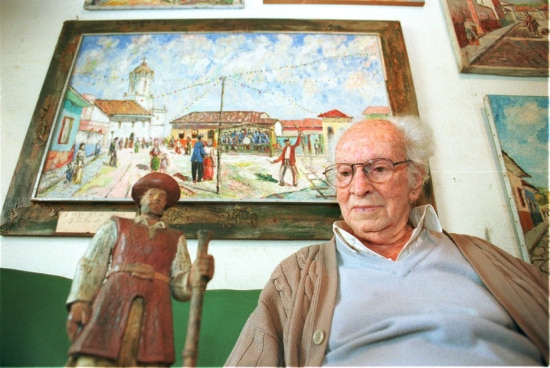 Júlio Guerra em sua casa com miniatura de sua estátua de Borba Gato em 2000.