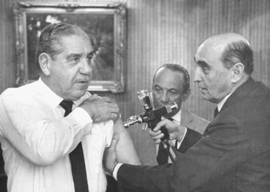 O ministro da Saúde, Leonel Mirando, vacina o presidenet Costa e Silva , Brasília, DF, 23/7/1967. 
 